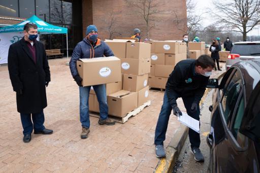 Volunteers loading boxes of food into cars at Western Campus